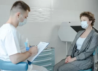 Lekarz w gabinecie medycyny estetycznej konsultuje się z pacjentką.